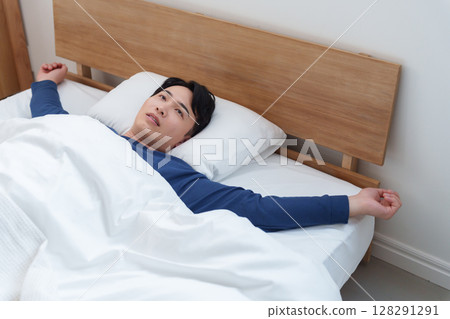 Depressed man resting in bed Depressed man resting in bed 128291291