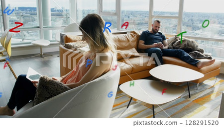 Image of letters flying over man and woman using electronic devices at home 128291520