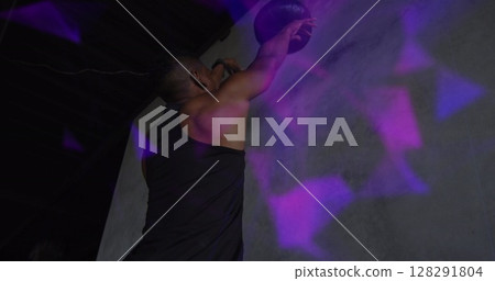 Image of colourful shapes over man exercising with a ball 128291804