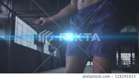 Digital composite image of blue spot of light against african american man jumping rope 128291815