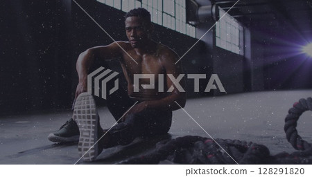 White particles against african american man taking a break from working out 128291820