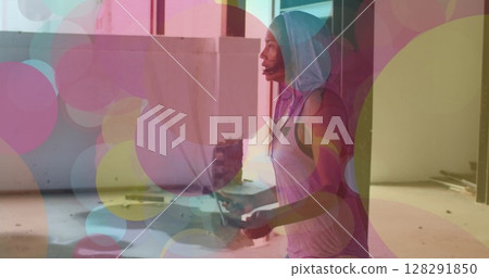 Colorful spots of lights moving against african american woman jumping ropes 128291850