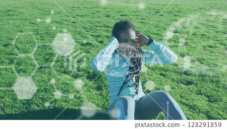 Chemical structures against african american woman performing crunches exercise in the garden 128291859