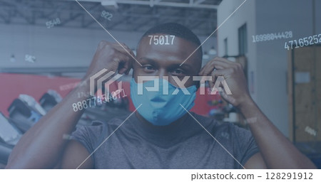 Image of numbers changing over man putting face mask on in gym 128291912