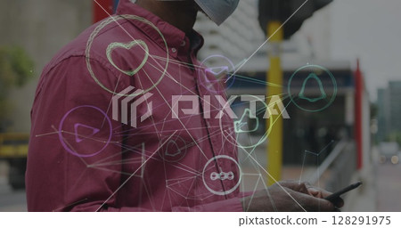 Image of network of digital icons over african american man in face mask using smartphone 128291975