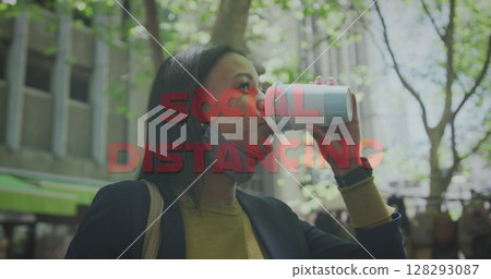 Image of social distancing text over woman drinking takeaway coffee in city wearing face mask 128293087