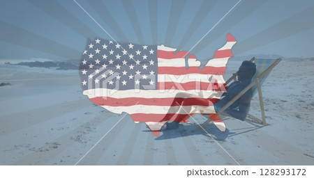 Image of american flag map waving over man having drink in deck chair on beach Image of american flag map waving over man having drink in deck chair on beach 128293172