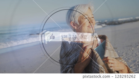 Image of speech bubble with thumbs up icon and numbers over senior woman on beach 128293262