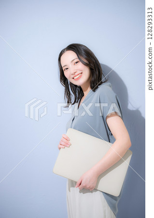 清爽的春夏短袖商務（辦公室休閒）女性，淺藍色背景上拿著筆記型電腦，工作變動，人事事務等。 128293313