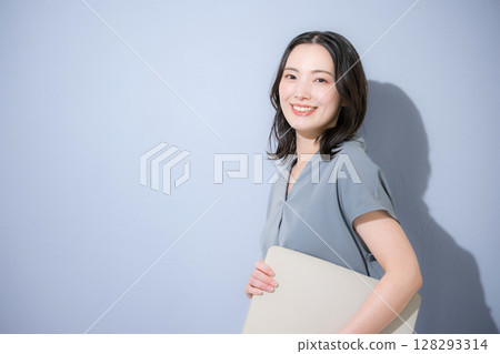 清爽的春夏短袖商務（辦公室休閒）女性，淺藍色背景上拿著筆記型電腦，工作變動，人事事務等。 128293314
