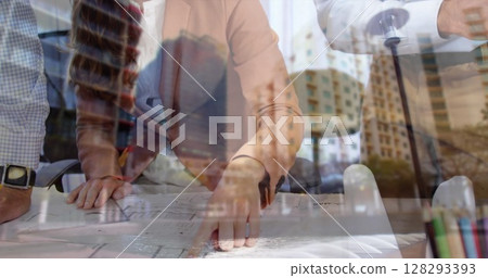 Architects collaborating on blueprints in modern office, planning urban development 128293393