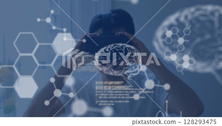 Exploring virtual reality, person using VR headset with digital brain graphics overlay 128293475