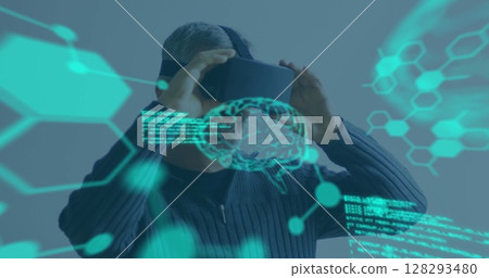 Man using VR headset exploring digital interface with futuristic graphics overlay 128293480