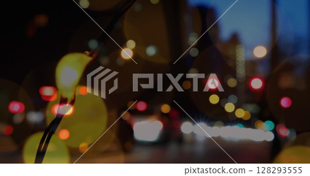 City streetlights glowing at night with blurred traffic in urban setting City streetlights glowing at night with blurred traffic in urban setting 128293555