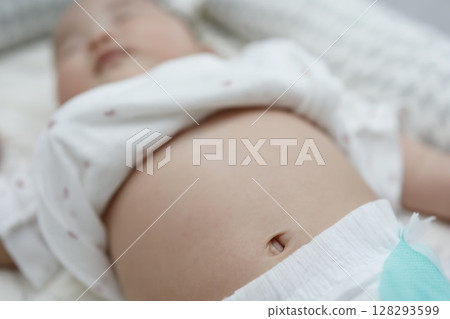 Close-up of a sleeping 0 year old baby's tummy and belly button Close-up of a sleeping 0 year old baby's tummy and belly button 128293599