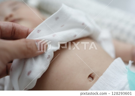 Close-up of a sleeping 0 year old baby's tummy and belly button Close-up of a sleeping 0 year old baby's tummy and belly button 128293601