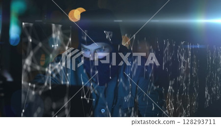 Hacker in dark room using laptop with digital network overlay, focused on screen Hacker in dark room using laptop with digital network overlay, focused on screen 128293711