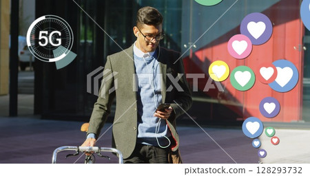 Young man walking with bicycle, using smartphone with 5G connectivity outdoors Young man walking with bicycle, using smartphone with 5G connectivity outdoors 128293732
