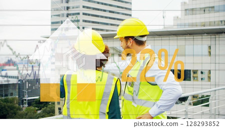 Construction workers in safety gear discussing project with city skyline backdrop 128293852
