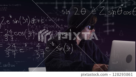 Hacker in hoodie using laptop with complex math equations on screen 128293861