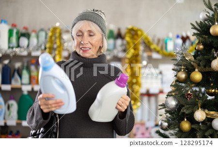 Elderly woman chooses detergent in supermarket before Christmas Elderly woman chooses detergent in supermarket before Christmas 128295174