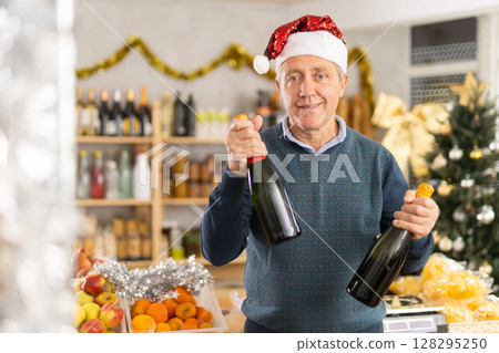 Elderly man choosing wine in grocery store Elderly man choosing wine in grocery store 128295250