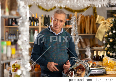 Elderly man with basket of groceries in store Elderly man with basket of groceries in store 128295252
