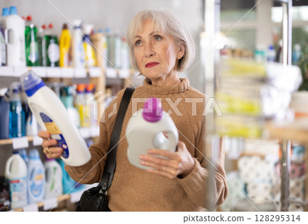 Mature woman choosing laundry detergent in department store 128295314