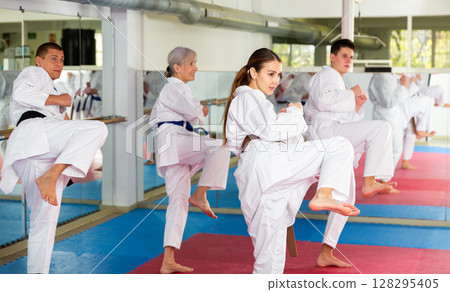 People of different ages performing kata in gym 128295405