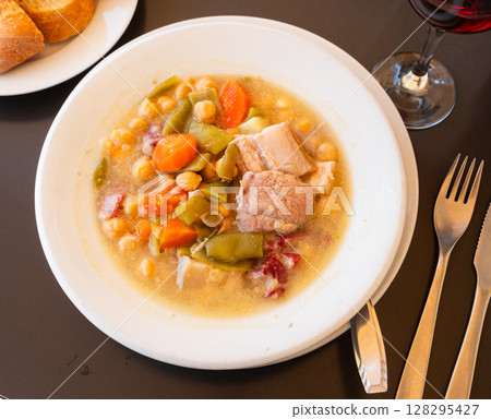 Popular dish of Spanish cuisine is Cocido de garbanzos, made from meat, vegetables and chickpeas, closeup 128295427