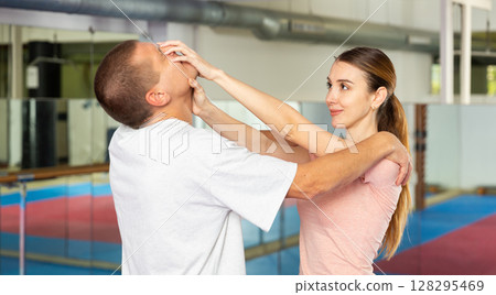 Self-defense course - woman strikes painful blow in the eyes of man Self-defense course - woman strikes painful blow in the eyes of man 128295469