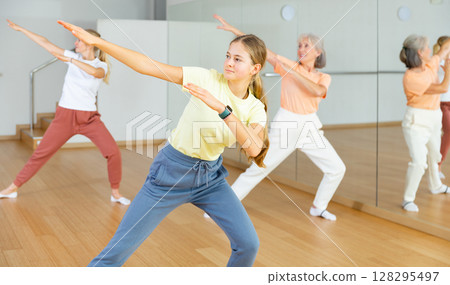 Girl dancing with her relatives during group training Girl dancing with her relatives during group training 128295497