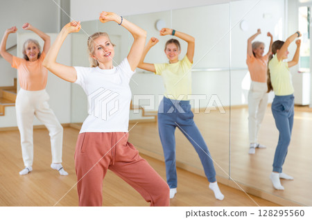 Female doing dance workout during group classe in fitness center 128295560