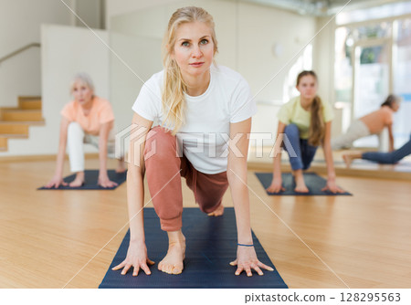 Woman practicing yoga in studio Woman practicing yoga in studio 128295563