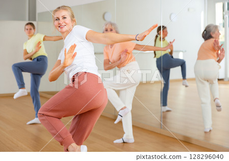 Woman performing aerobic dance during group training 128296040