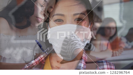 Digital composition of asian woman wearing face mask against college student studying at college Digital composition of asian woman wearing face mask against college student studying at college 128296764