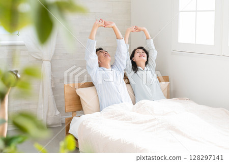 一對夫婦醒來並在床上交談 128297141