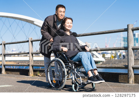 父母和孩子推著輪椅四處走動 128297175