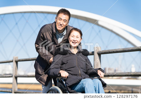父母和孩子推著輪椅四處走動 128297176