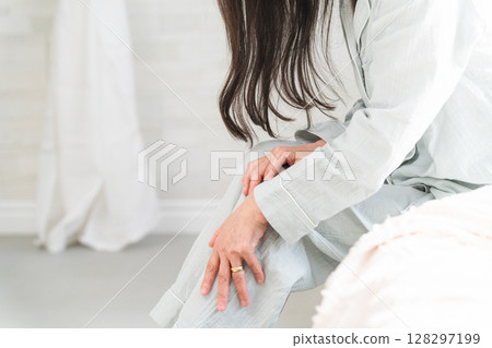 女人在床上醒來抱怨膝蓋疼痛 128297199