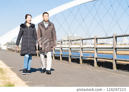 A middle-aged couple walking along a promenade A middle-aged couple walking along a promenade 128297223
