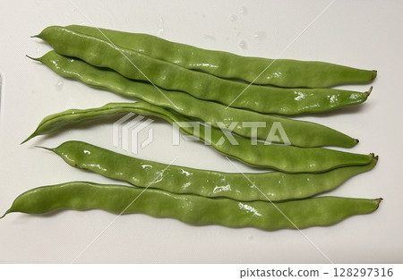 Fresh Moroccan beans lined up with water droplets on a white background Fresh Moroccan beans lined up with water droplets on a white background 128297316