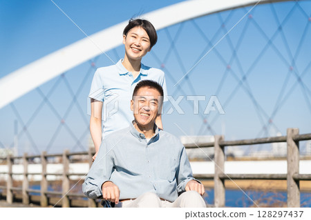 一名男子和他的護理人員推著輪椅四處走動 128297437