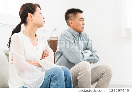 Mature couple sitting on sofa 128297449