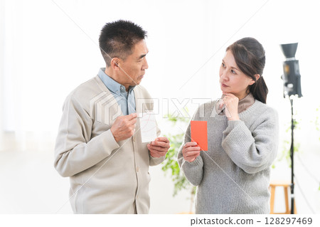 一對中年夫婦正在討論新年禮物的價格 一對中年夫婦正在討論新年禮物的價格 128297469