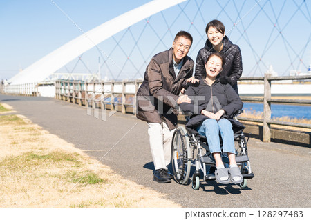 父母和孩子推著輪椅四處走動 父母和孩子推著輪椅四處走動 128297483