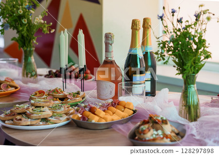 Elegant Champagne Brunch Spread on Pink Tablecloth with Flowers and Candles, Vibrant Interior Background, Festive Party Still Life. 128297898