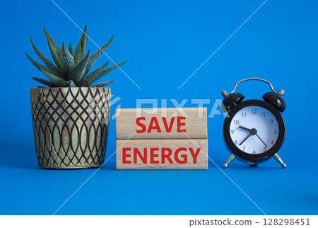 Save Energy symbol. Wooden blocks with words Save Energy. Beautiful blue background with alarm clock and succulent plant. Business and Save Energy concept. Copy space. Save Energy symbol. Wooden blocks with words Save Energy. Beautiful blue background with alarm clock and succulent plant. Business and Save Energy concept. Copy space. 128298451