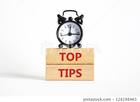 Top Tips symbol. Concept words Top Tips on wooden blocks. Beautiful white background with alarm clock. Business and Top Tips concept. Copy space. Top Tips symbol. Concept words Top Tips on wooden blocks. Beautiful white background with alarm clock. Business and Top Tips concept. Copy space. 128298463