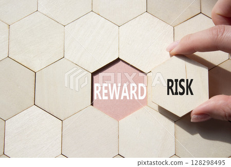 Risk or Reward symbol. Concept word Risk or Reward on wooden comb puzzle. Businessman hand. Beautiful pink background. Business and Risk or Reward concept. Copy space 128298495